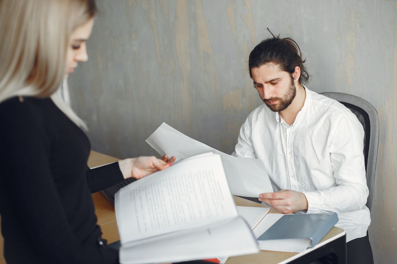 Crafting Captivating Headlines: Your awesome post title goes here Two professionals reviewing important documents in a modern office setting.